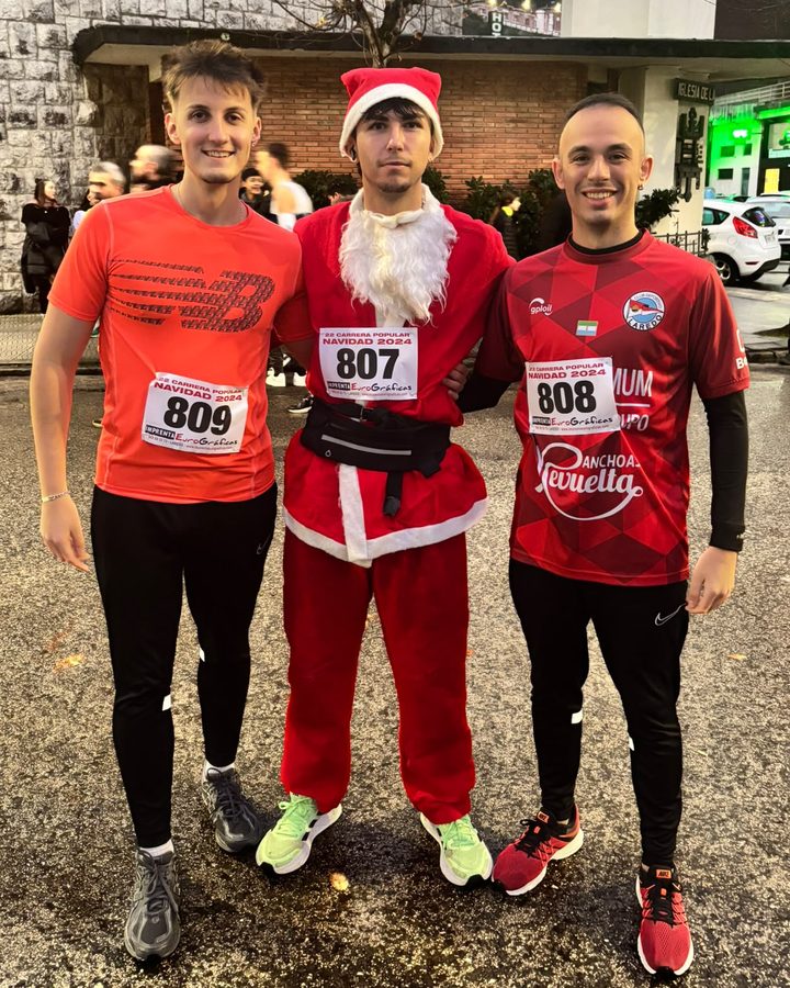 Mario y dos amigos con dorsales en una carrera de Navidad, uno vestido de Papá Noel