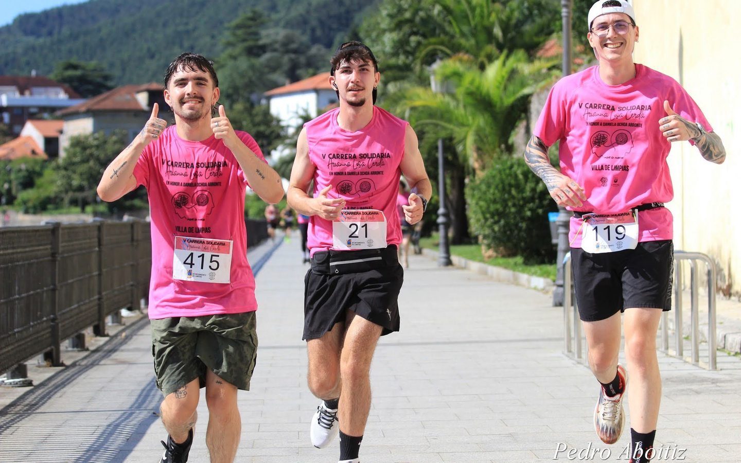 Mario y dos amigos con camisetas rosas corriendo una carrera solidaria