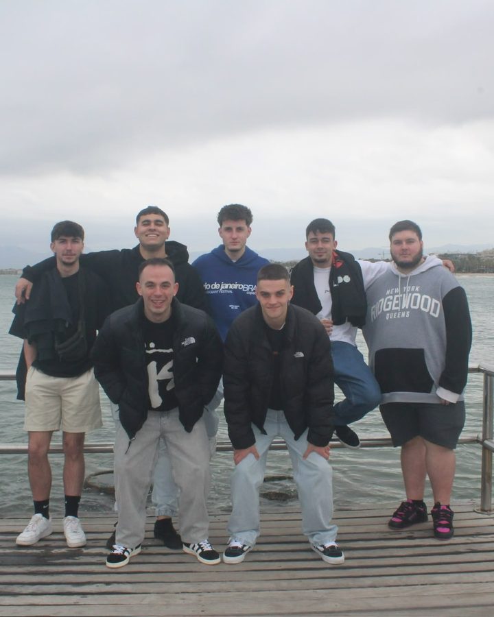 Grupo de amigos posando en un muelle junto al mar