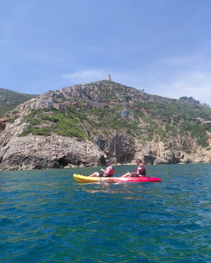 Dos personas en un kayak junto a un acantilado