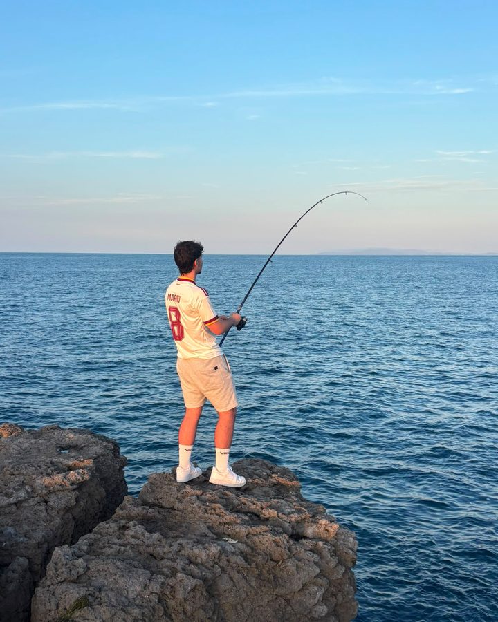 Mario pescando desde unas rocas frente al mar