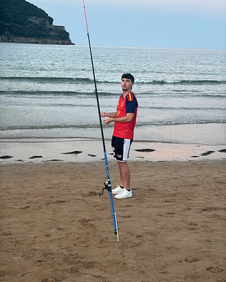 Mario junto a una caña de pescar en la orilla de la playa