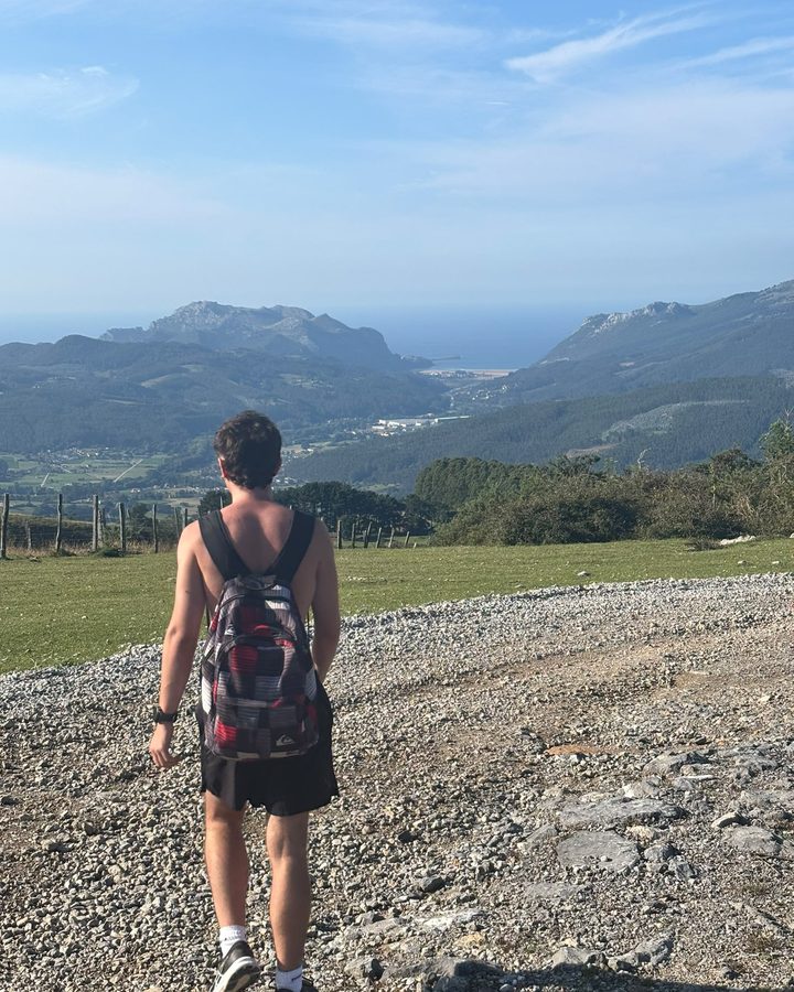 Mario de espaldas con mochila en un camino de montaña