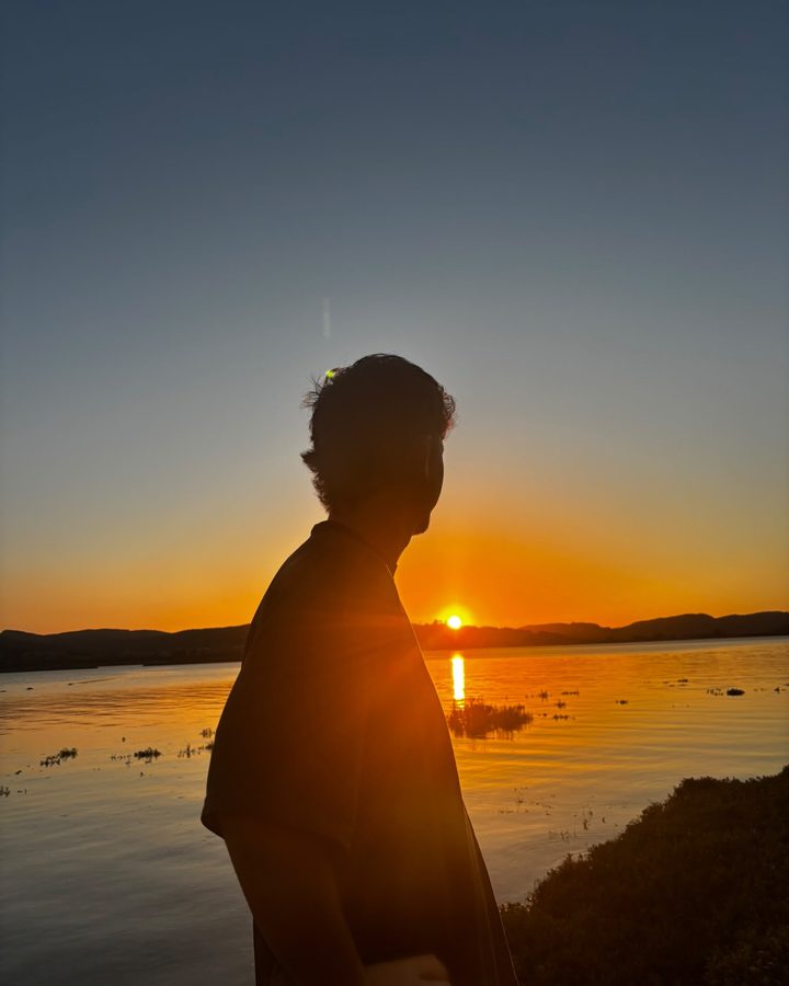 Silueta de Mario frente a la puesta de sol sobre el agua
